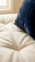 Cozy bedroom scene with navy blue linen pillow resting on cream-colored quilted bedding, natural window light creating warm ambiance, perfect for home decor and lifestyle content.