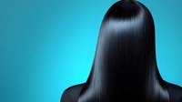 Silky smooth black straight hair on turquoise background, back view of woman with glossy healthy long hairstyle showing professional salon treatment results.