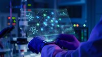 Scientist in laboratory holding transparent tablet displaying molecular network visualization with glowing connections and data analysis interface.