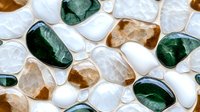 Polished stones and crystals in white, green, and brown tones arranged on white background, suitable for wellness, spa, and healing product design.