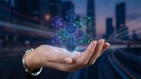 Open hand holding glowing geometric holographic cubes above city skyline at dusk, representing digital innovation, blockchain technology, and future business solutions.