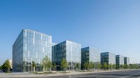 Modern glass office buildings with reflective facades in business district under clear blue sky for corporate architecture and commercial real estate projects.