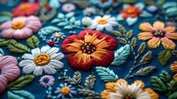 Colorful embroidered flowers and leaves on dark blue fabric create delicate floral pattern with dimensional texture and intricate needlework details.