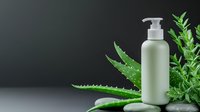Natural skincare cosmetic bottle with pump dispenser surrounded by fresh aloe vera and green plants on clean surface for organic beauty products.