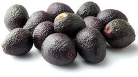Fresh ripe dark purple avocados scattered on white background, macro food photography with soft shadows. Organic produce for healthy eating concept.