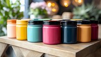 Colorful reusable insulated travel mugs and tumblers in pastel and vibrant colors arranged on wooden surface with soft bokeh background. Modern eco-friendly lifestyle.