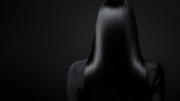 Professional woman with long straight black hair viewed from behind against dark background for business and corporate design concepts.