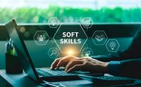 Professional typing on laptop with soft skills icons overlay representing communication, teamwork, leadership and problem-solving abilities in modern workspace.