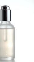 Luxury cosmetic serum bottle with silver pump dispenser isolated on white background for skincare and beauty product packaging design.