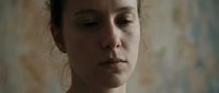 Middle-aged woman with fair skin and dark hair pulled back, displaying a contemplative or melancholic expression. Suitable for mental health, wellness, psychology, and emotional well-being editorial and commercial projects.