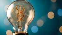 Light bulb with glowing dollar sign filament symbolizing profitable business ideas, financial innovation and money-making concepts on blue bokeh background.
