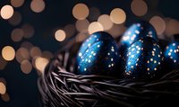 Dark blue Easter eggs decorated with silver glitter stars nestled in black woven basket against blurred warm bokeh lights creating magical holiday atmosphere.