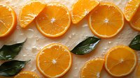 Fresh orange slices arranged in rows with green leaves and water drops on light background, top view composition for healthy eating and citrus concepts.