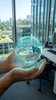 Businessman hands holding holographic digital globe with network icons in modern office overlooking city skyline for technology and connectivity concepts.