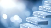 Frozen crystalline structure with water droplets in blue tones, macro photography showing delicate ice formations against blurred bokeh background, winter abstract pattern.