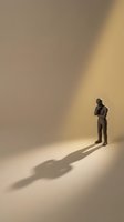 Contemplative male professional in business suit standing alone in minimalist space with dramatic shadow, representing solitude, decision-making, and corporate introspection for business concepts.