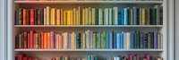 Colorful books arranged by rainbow spectrum on wooden bookshelf. Organized collection of hardcover volumes creates vibrant gradient display for home library or bookstore.