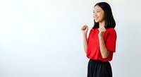 Young East Asian woman wearing bright red short-sleeve shirt and dark skirt, smiling while gesturing with hand raised, isolated on white background for portrait and lifestyle use.