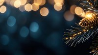 Pine branch with golden lights against dark blue bokeh background creates magical winter holiday atmosphere, festive Christmas corner decoration.