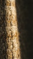Natural jute rope close-up with frayed fibers and rustic texture against dark background for nautical and craft projects.