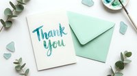 Watercolor thank you greeting card with mint green envelope, eucalyptus branches, and sea glass on white background, flat lay style.