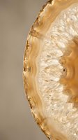 Golden agate slice with natural banded patterns and crystalline formations for luxury interior design and geological collections.