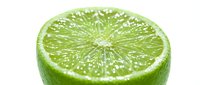 Fresh lime slice with water droplets isolated on white background, suitable for beverage, food, and culinary design projects.