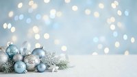 Blue and silver ornaments with evergreen branches and white stars on snowy surface against soft bokeh lights, suitable for holiday greeting cards and festive seasonal marketing materials.