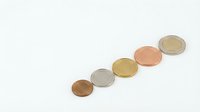 Isolated metallic coins arranged in diagonal line on white background, representing currency, finance, savings, and wealth accumulation for business and economic design projects.