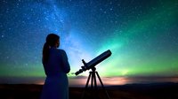 Young woman silhouetted against spectacular northern lights and starry sky observes cosmos through telescope, creating magical astronomy moment at night.