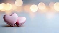 Pink heart decorations on soft blue background with golden bokeh lights creating romantic Valentine's day mood, love concept for greeting cards and designs.