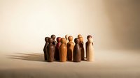 Group of wooden figurines standing together in warm tones, representing diversity, unity, and community for business, teamwork, and organizational concepts.