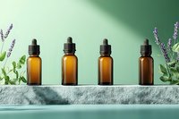 Amber glass essential oil bottles arranged in row on stone surface with lavender and eucalyptus leaves, green background. Wellness and aromatherapy concept.