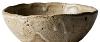 Rustic handmade ceramic bowl with textured beige surface and irregular edges, isolated on white background, ready for design use.