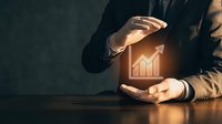 Businessman in dark suit holding glowing growth chart icon, representing financial success, business analytics, investment returns, and corporate performance metrics for marketing.