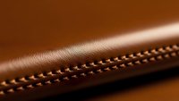 Brown leather surface with decorative stitching detail showcasing craftsmanship and texture for luxury goods and fashion accessories design projects.