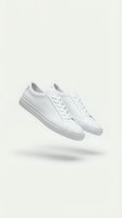 Pair of white leather low-top sneakers floating on a light background, showcasing minimalist style and clean design for fashion and footwear concepts.