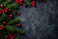 Christmas decorative corner arrangement with fresh pine branches, red berries and baubles on dark textured background with copy space for seasonal designs.