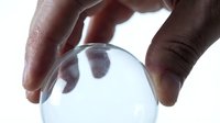 Hands holding transparent glass sphere crystal ball for fortune telling divination and mystical predictions on white background.