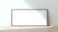 Minimalist wooden frame mockup with white mat leaning against wall on wooden floor for artwork display and interior design presentations.