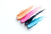 Colorful makeup smears on white background showing peach, pink, navy blue and turquoise cosmetic textures for beauty product advertising.