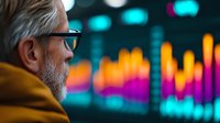 Senior Caucasian businessman with gray hair and glasses looking at colorful financial market data charts and graphs displayed on digital screen in dark office.