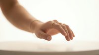Gentle human hand reaching out in soft warm light with peaceful gesture conveying care, support, and connection for wellness and healing concepts.