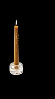 Tall golden taper candle in clear glass holder, isolated on transparent background. Ready for design use on t-shirts, stickers, print-on-demand products, and digital crafts.