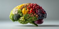 Brain-shaped arrangement of fresh colorful fruits and vegetables representing healthy nutrition and mental wellness for cognitive health concepts.