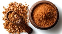 Ground and crushed brown sugar in wooden bowl and scoop on white background, top view. Natural sweetener for baking and cooking.