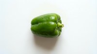 Fresh green bell pepper isolated on white background, suitable for food, cooking, nutrition, and healthy eating design projects.