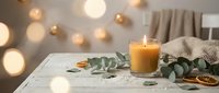 Cozy home interior with burning candle, eucalyptus leaves and warm bokeh lights creating peaceful atmosphere for relaxation and wellness lifestyle.