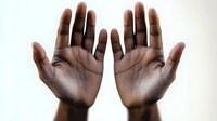 African American open palms raised up against white background showing dark skin texture and life lines, symbolizing surrender, prayer or showing empty hands.