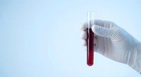 Medical professional holding blood sample test tube in laboratory for diagnostic analysis and healthcare research.